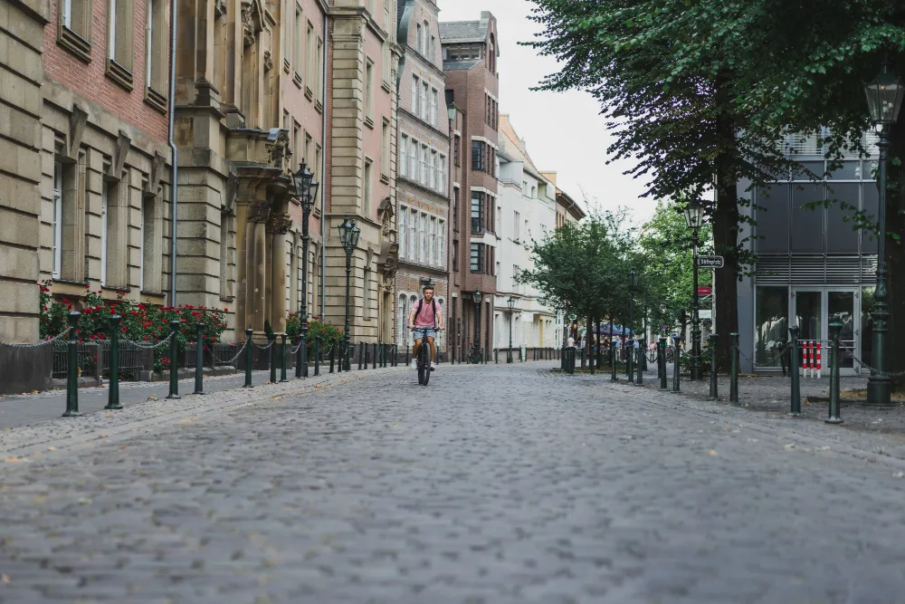 A cyclist on a quiet cobbled Austrian street