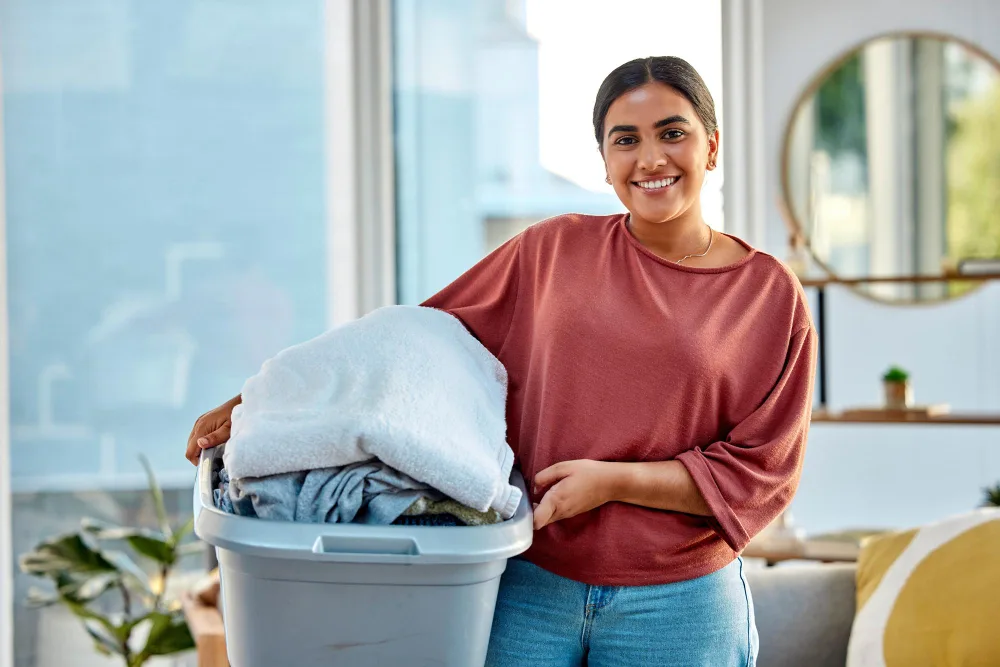 Person holding a laundry basket in a bright living room