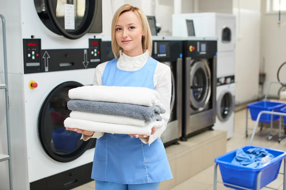 Laundry attendant holding folded towels